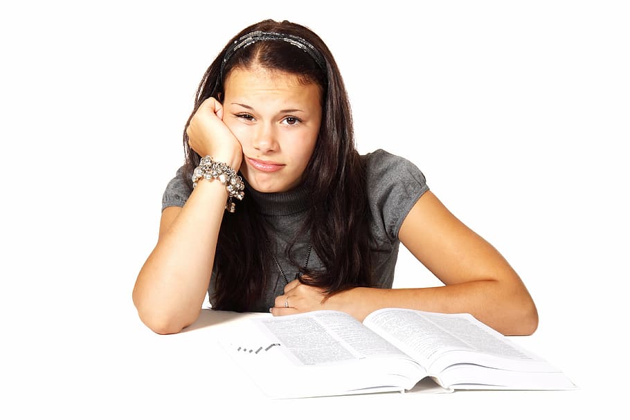 woman wearing gray shirt in front of open book, bored, college
