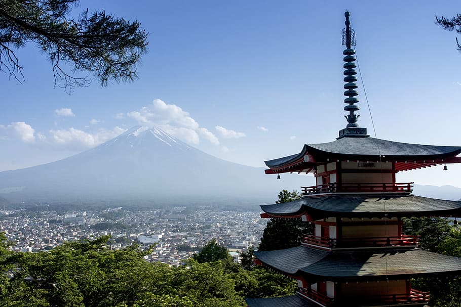 brown and white pagoda in front of volcano at daytime, Japan