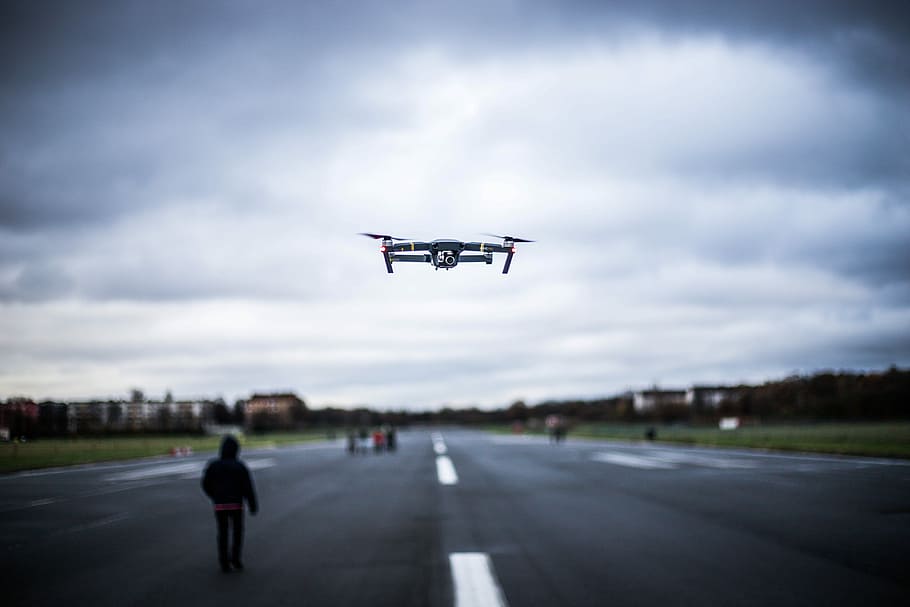 white drone flying near road, turned-on gray and red quadcopter drone on air HD wallpaper