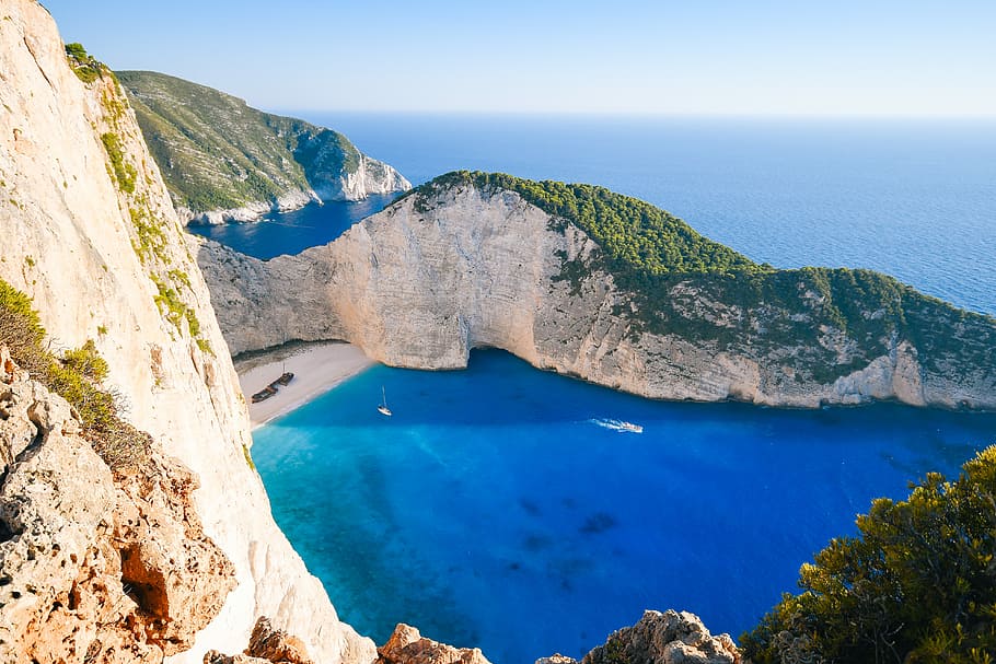 photography of blue ocean, aerial photo of body of water near rock formation HD wallpaper