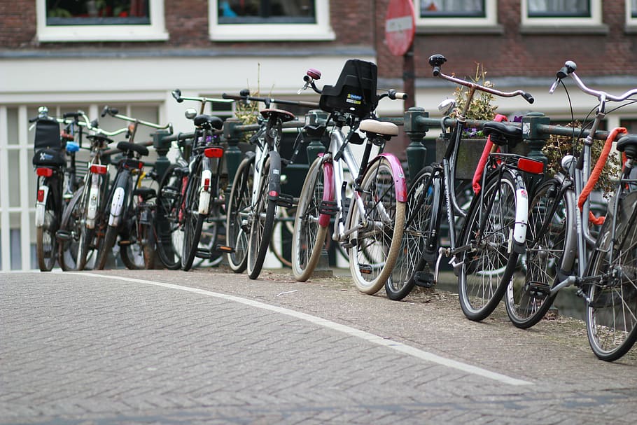 assorted-color bicycles parked on concrete pavement, amsterdam HD wallpaper