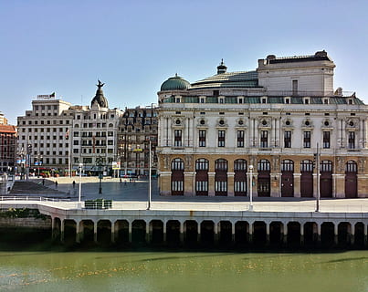white and brown concrete buildings near calm body of water HD wallpaper