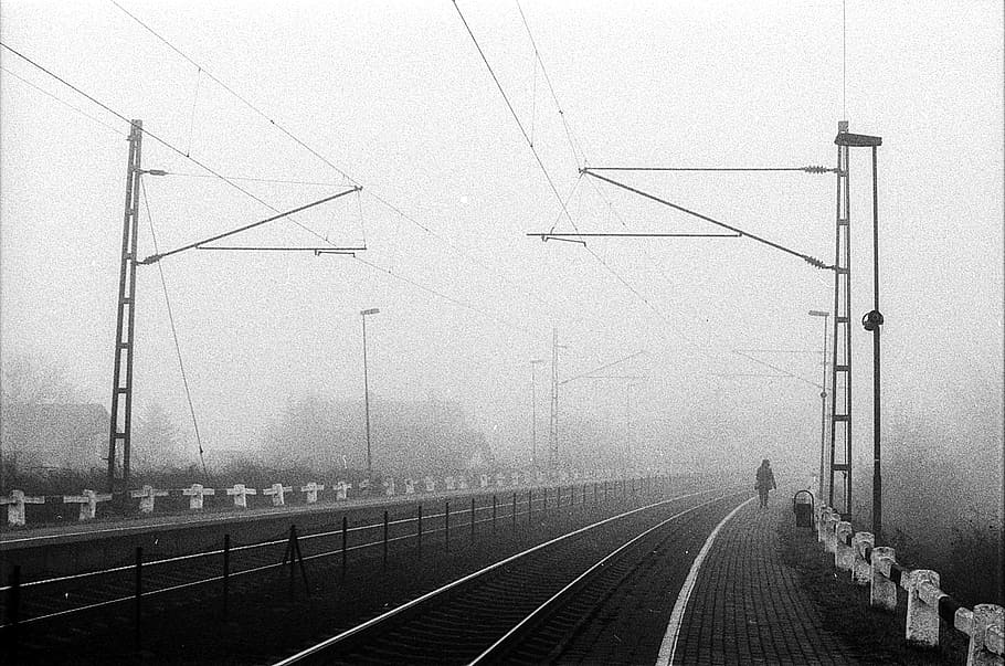 railroad during daytime, fog, train station, moody, black and white
