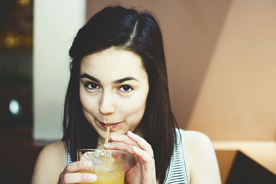 woman wearing white and black striped scoop-neck sleeveless shirt holding clear drinking glass HD wallpaper