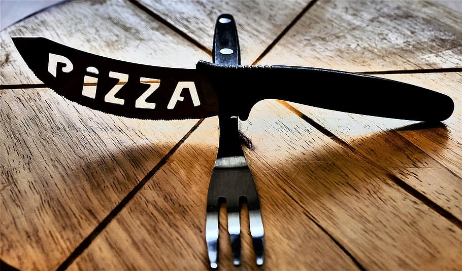 black pizza knife above fork on brown pizza board, abstract HD wallpaper