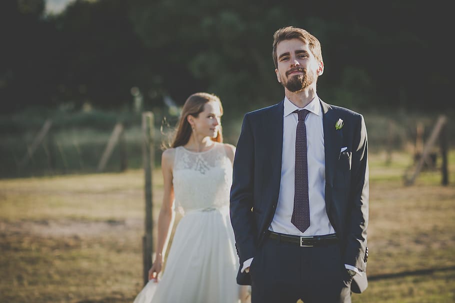 man in black suit jacket beside woman in white sleeveless dress HD wallpaper