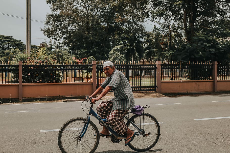 man riding bike near beige wall during daytime, man riding blue bicycle HD wallpaper