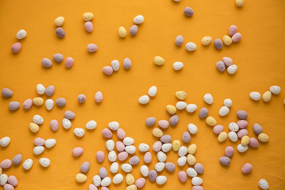 pebble stones on orange surface, white and purple egg minitaures HD wallpaper