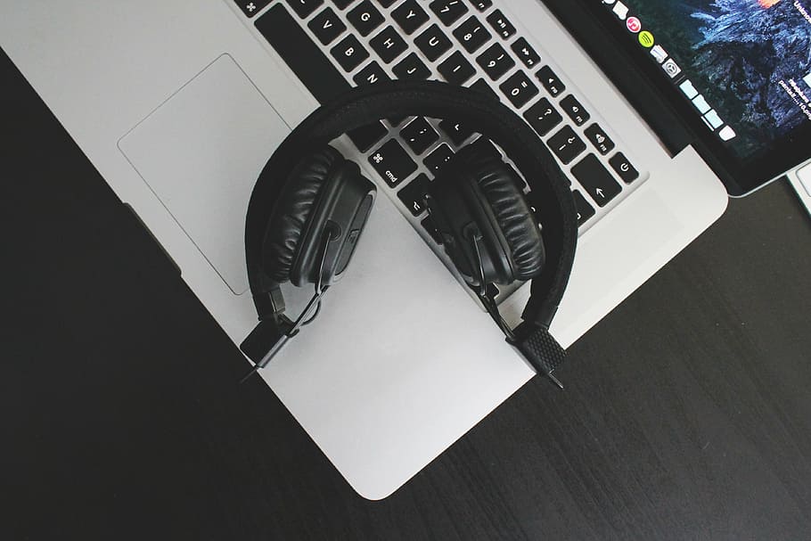 black wireless headphones on top of MacBook Pro, audio, laptop