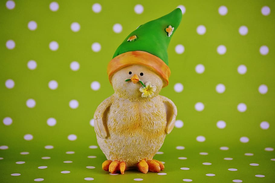 duckling biting yellow petaled flower figurine on green and white polka-dot surface HD wallpaper