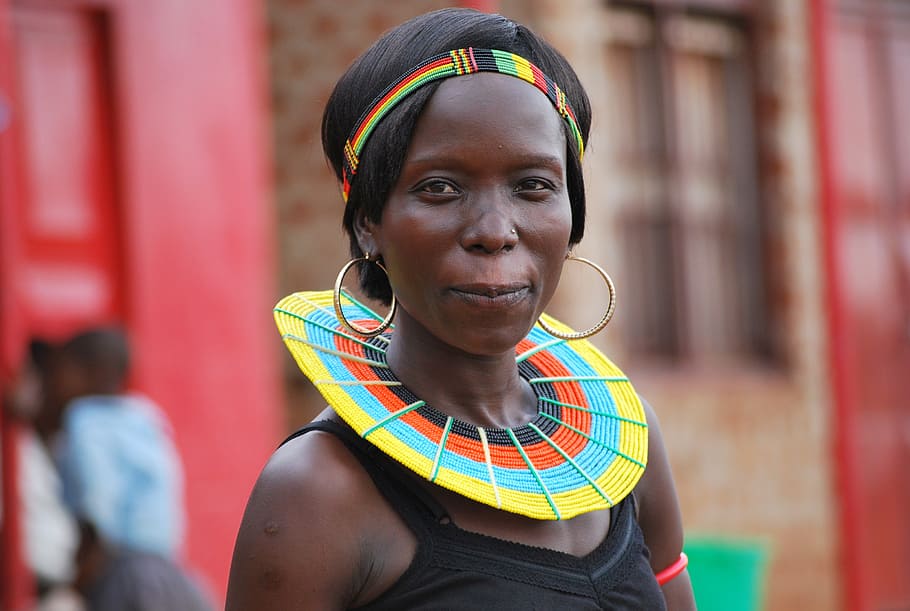 woman wearing black tank top and gold-colored hoop earrings, masai