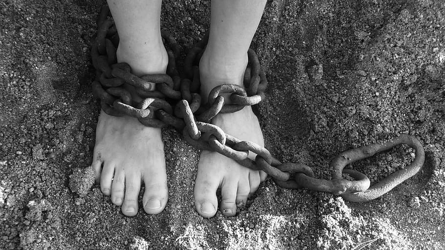 grayscale photography of person with chain on both feet, chains