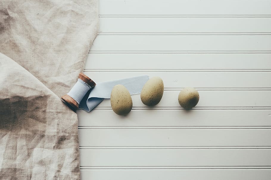 three oval gray pebbles, three brown stones, flat lay, eggs, linen HD wallpaper