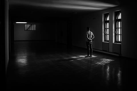 Grayscale photo of man standing near window photo – Free Cloud