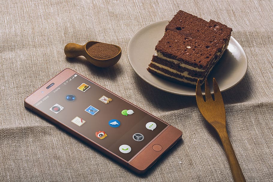 sliced chocolate cake in gray saucer near opened smartphone HD wallpaper