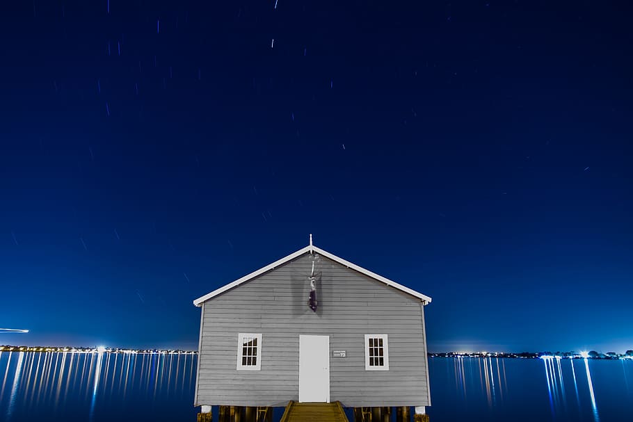 gray house surrounded with body of water photo, gray and white cabin during at night HD wallpaper