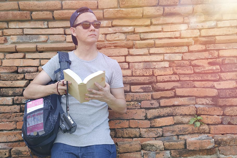 man, person, sunglasses, camera, book, boy, bricks, cap, casual HD wallpaper