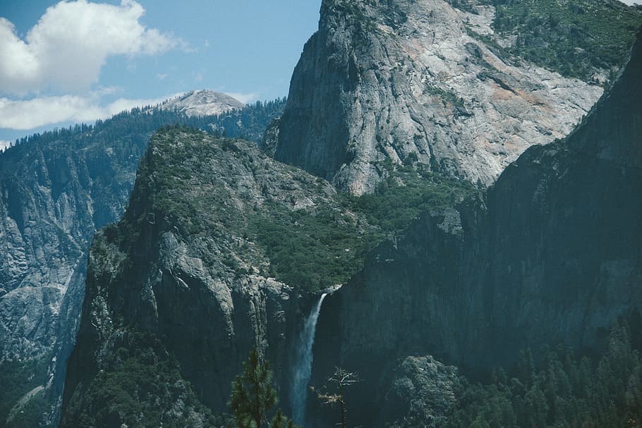 bird's eye photography of mountain covered trees, mountain with falls under blue sky HD wallpaper
