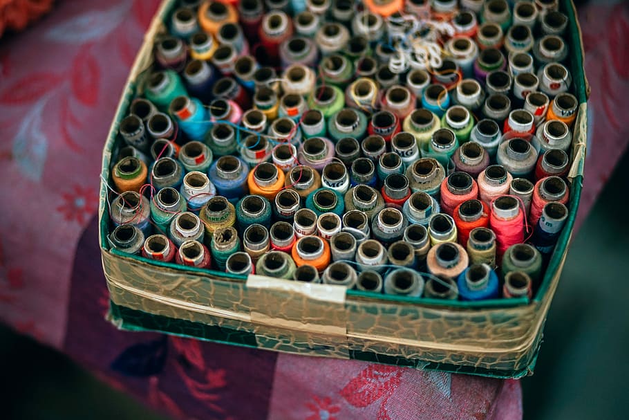 Colorful Spools, assorted-color threads in box on floral textile HD wallpaper