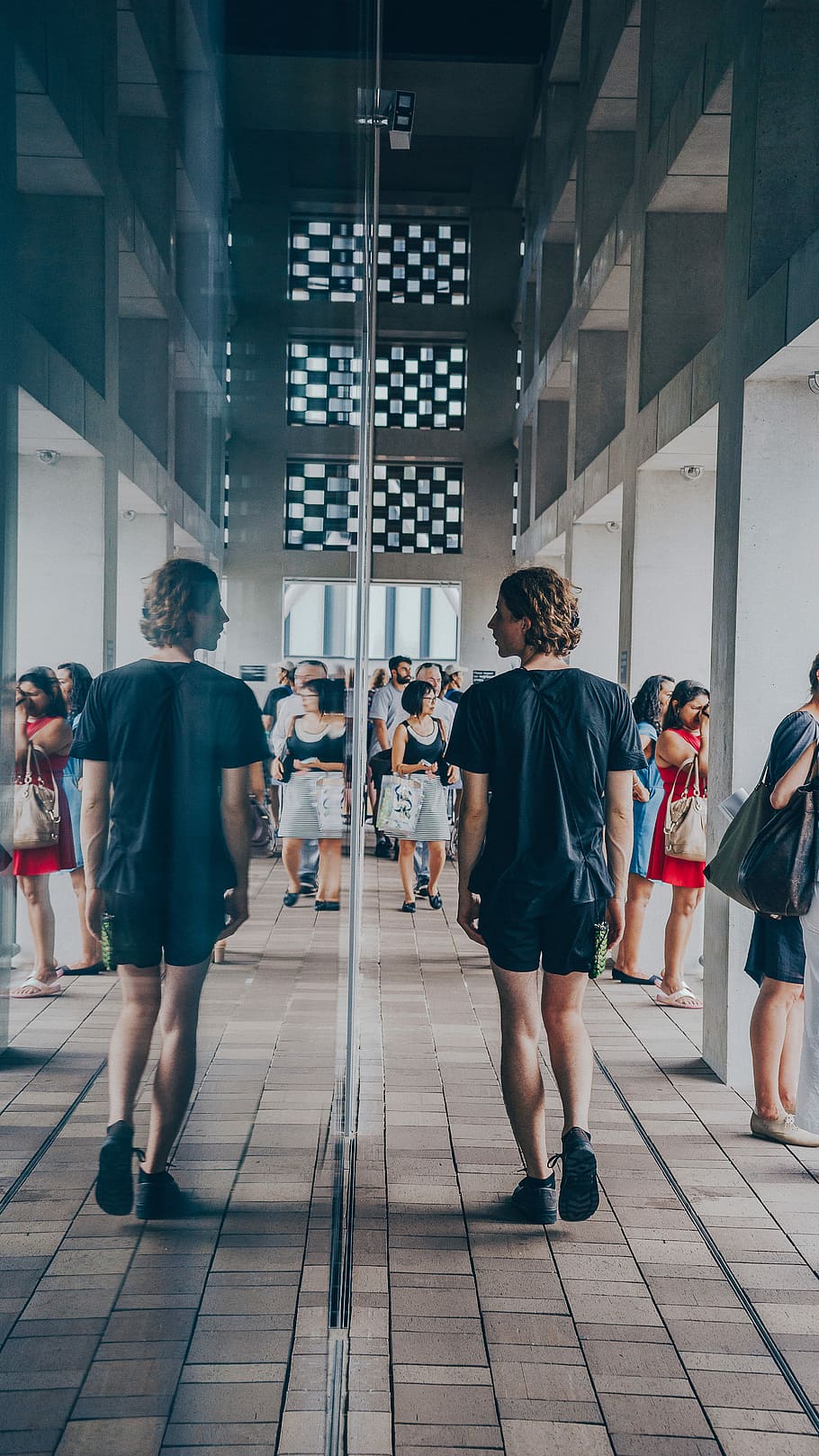 man walking beside mirror wall building, man walking beside mirror facing his face HD wallpaper