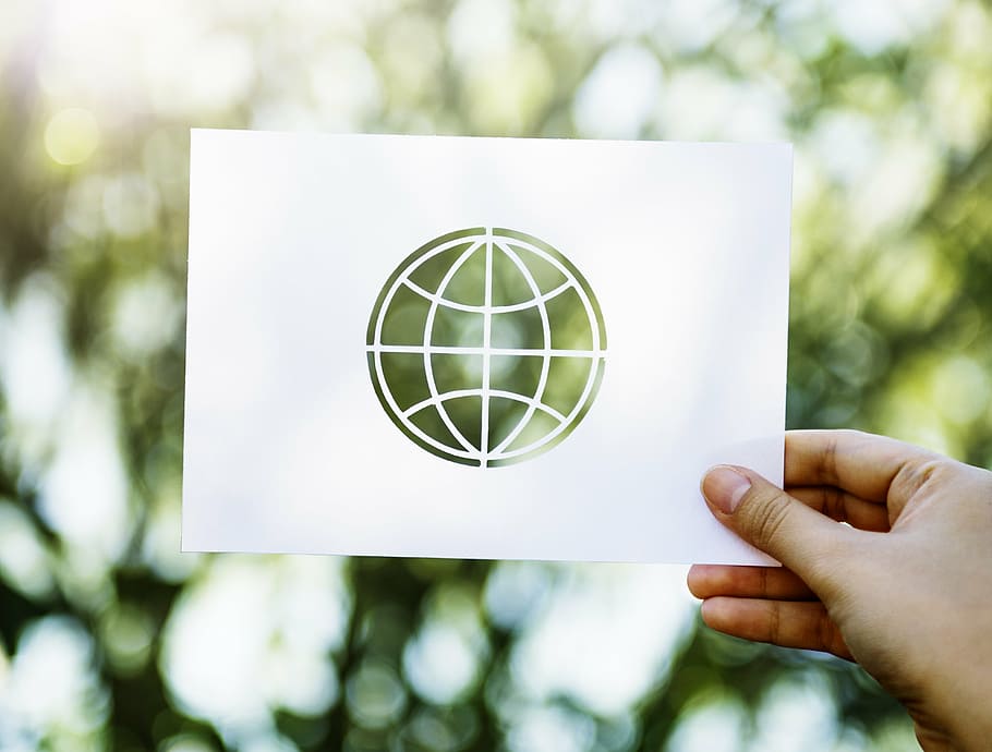 person holding up card with world logo, bokeh, blur, plants HD wallpaper