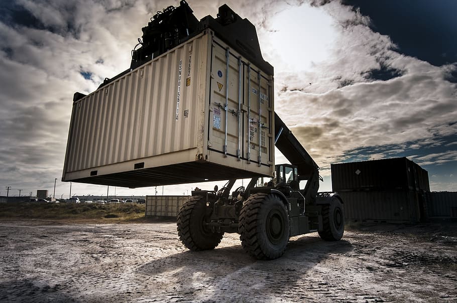 cargo container lifted by vehicle, loading, transport, industrial
