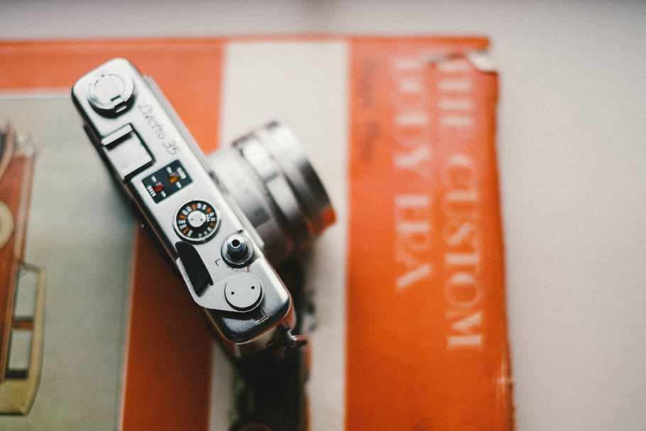 selective focus silver point-and-shoot camera, gray point-and-shoot camera on The Custom book HD wallpaper