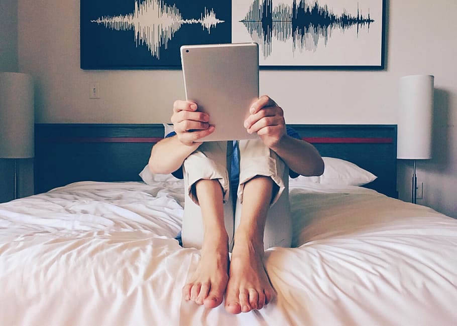 photo of person holding gray tablet while sitting on bed, ipad HD wallpaper