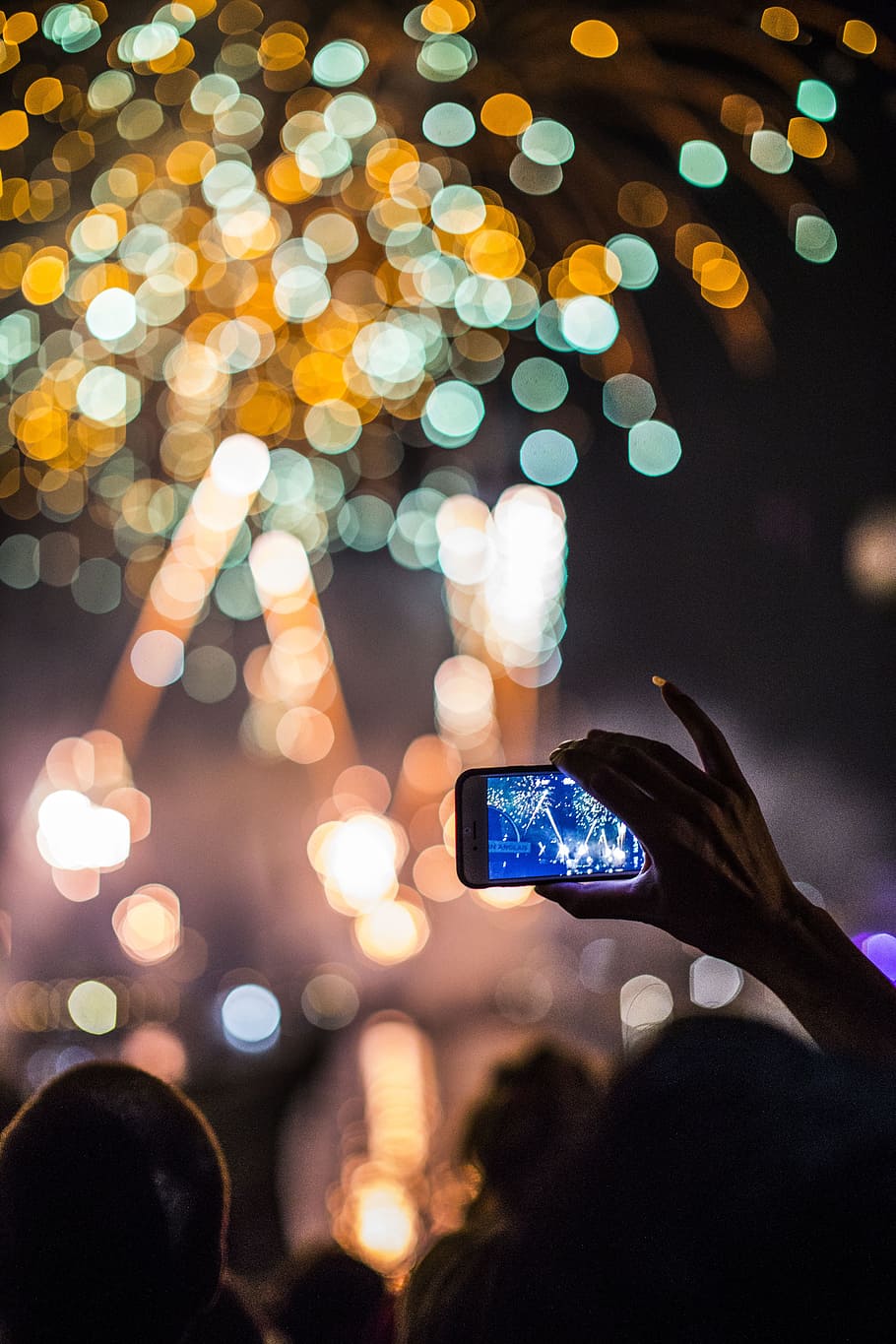 person holding smartphone capturing fireworks, selective focus photography of person taking photo of fireworks display HD wallpaper