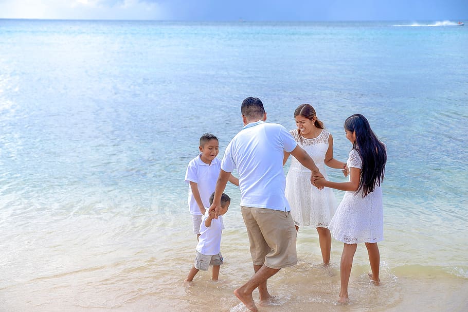 family holding hands circle on seashore at day time, vacation