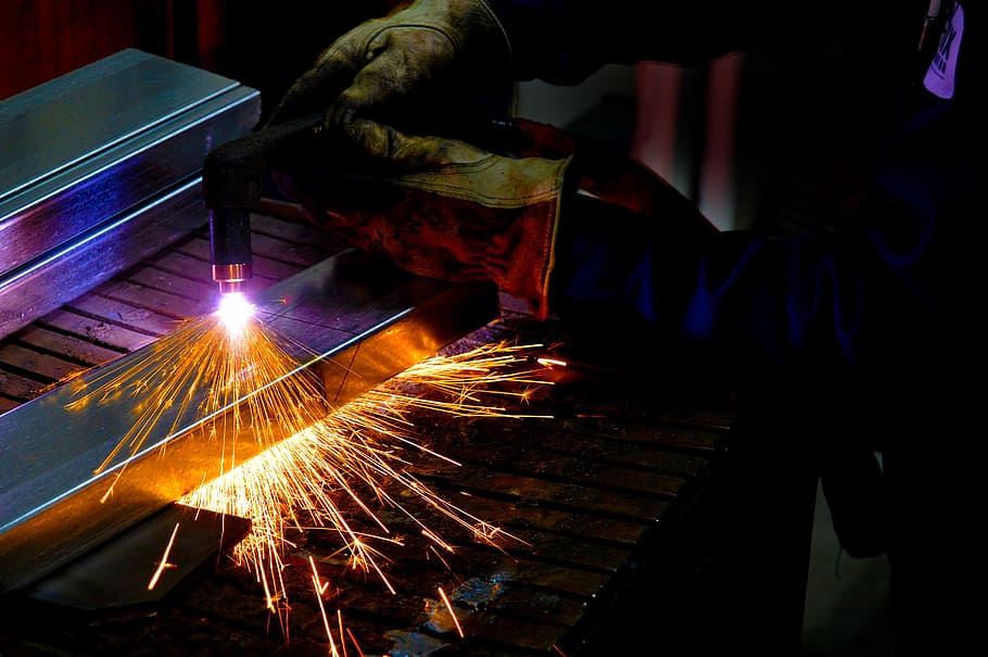 man holding welding torch, person torching metal, light, sparks