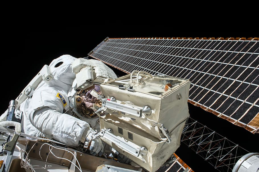 closeup photo of astronaut repairing satellite, astronaut in space on satellite