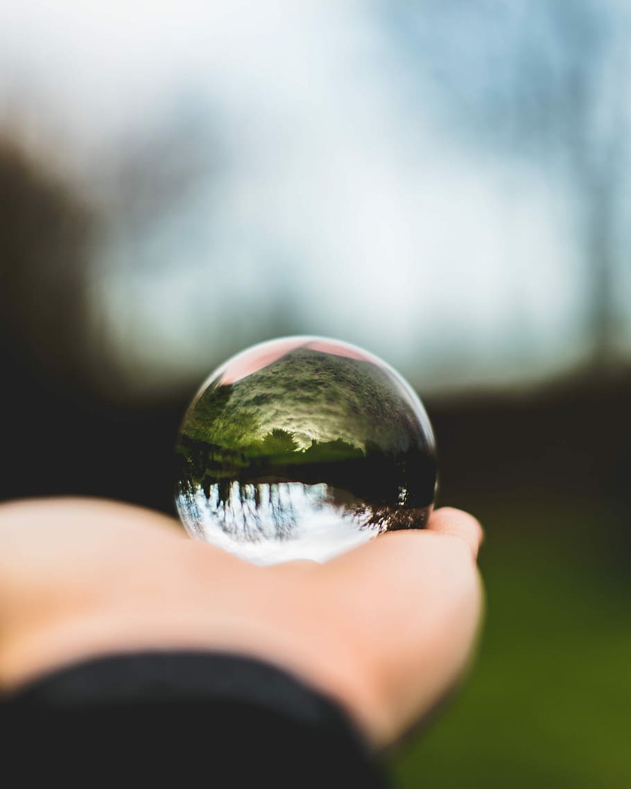 person holding round glass ball, selective focus photography of hand HD wallpaper