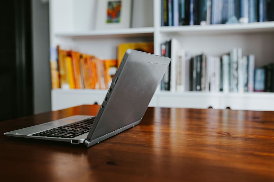 Silver laptop with various items on a table, magazines, computer HD wallpaper
