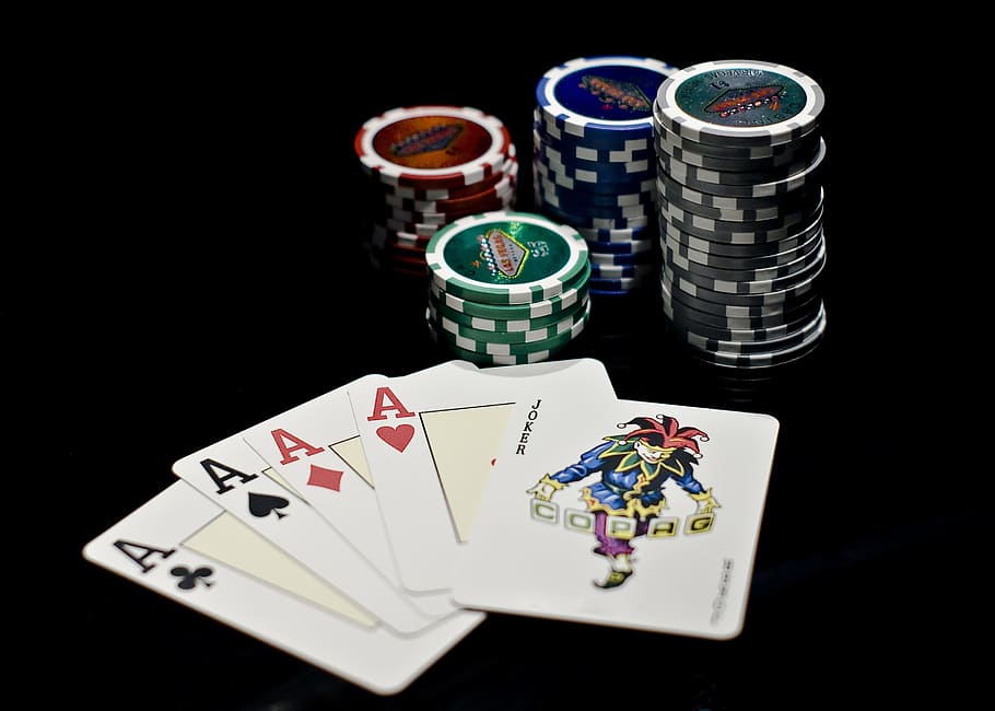 four Ace playing cards next to poker chips, letters, deck, casino