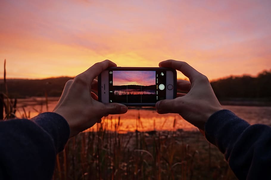 Man capturing a stunning sunset with his mobile iPhone smartphone camera, HD wallpaper