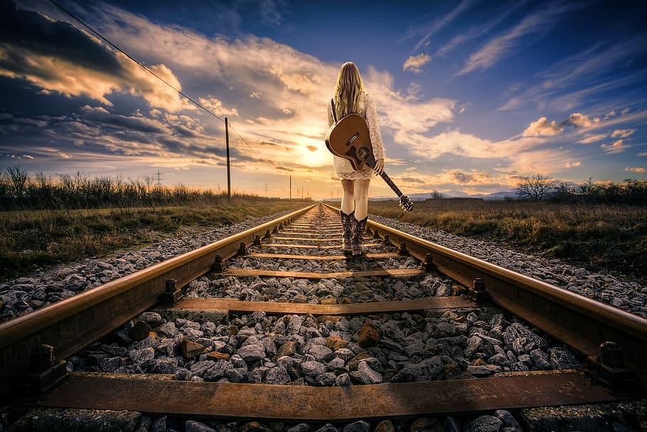 woman carrying acoustic guitar standing on railroad during daytime, HD wallpaper
