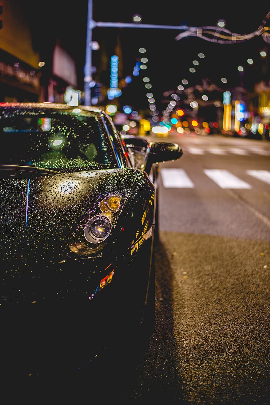 close photography of black convertible on road, black Lamborghini with water drops during night time
