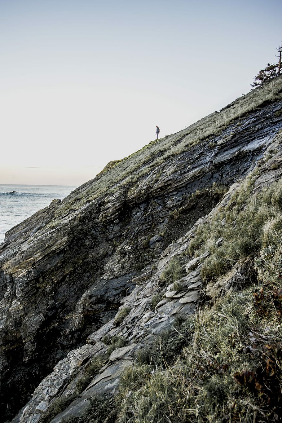 man on stony mountain under blue skies, rock, hill, cliff, sea HD wallpaper