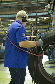 man holding gray and blue air power tool beside tire, work HD wallpaper