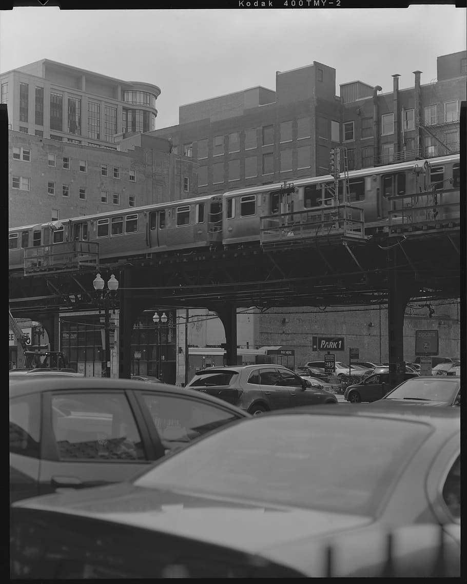 grayscale photography of cars under the trail rails, grayscale photography of vehicles under train HD wallpaper