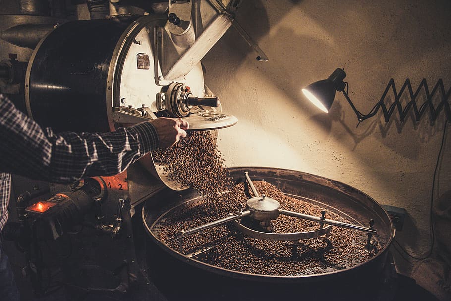 person pouring coffee beans on a machine, person grinding coffee using machine HD wallpaper