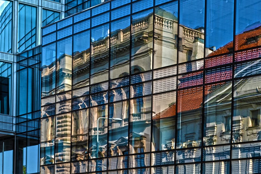 clear curtain wall building with a reflection of gray concrete building taken during daytime HD wallpaper