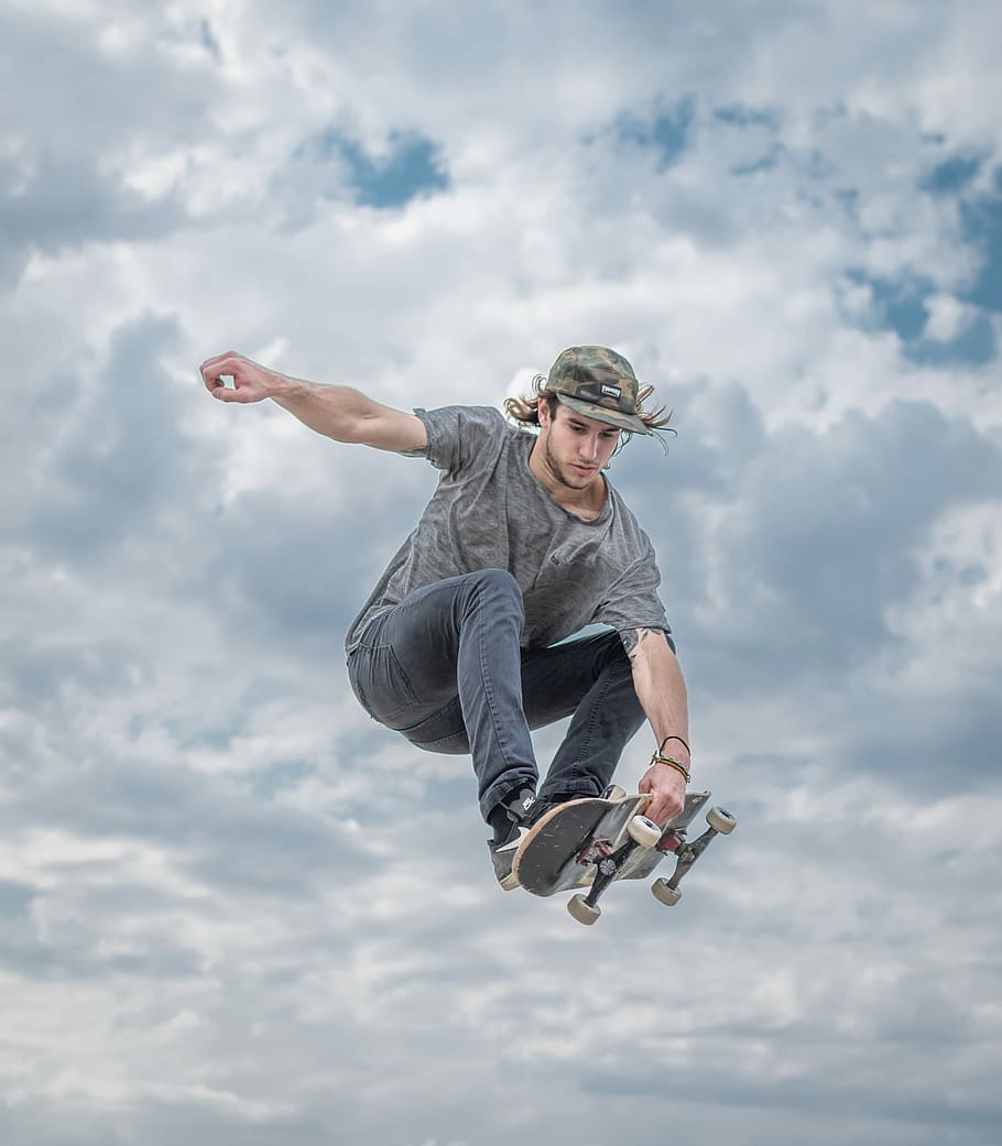 Free Download Hd Wallpaper Jump Man Doing Tricks On Skateboard Under Cloudy Skies Skater