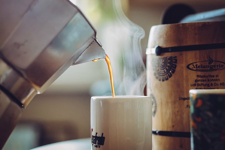 gray moka pot filling coffee in white mug, cup, cup of coffee