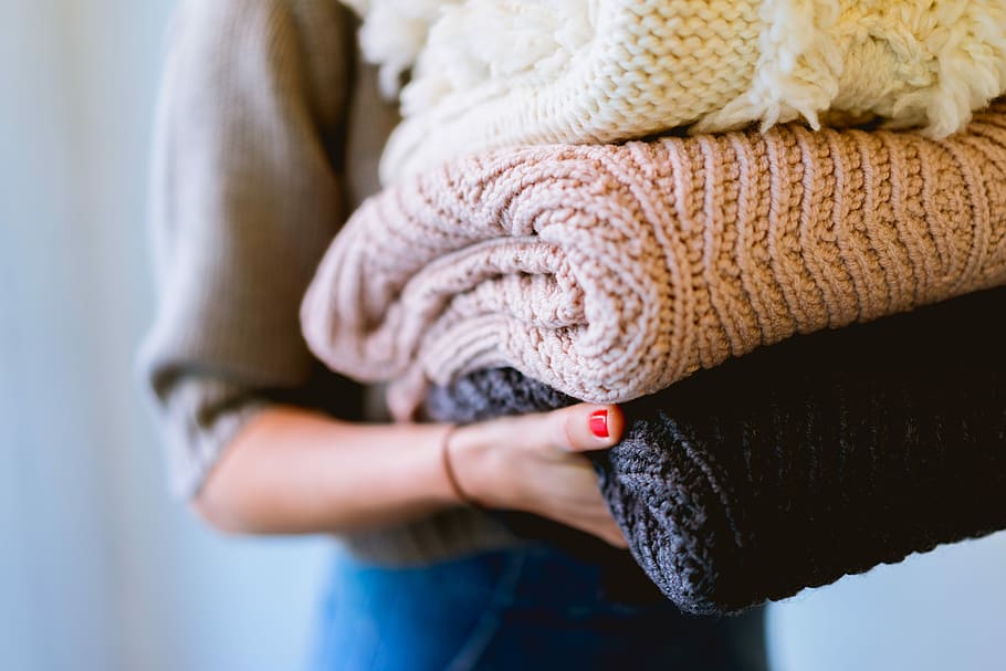 person holding knitted textiles, closeup photo of person carrying knitted cloths HD wallpaper
