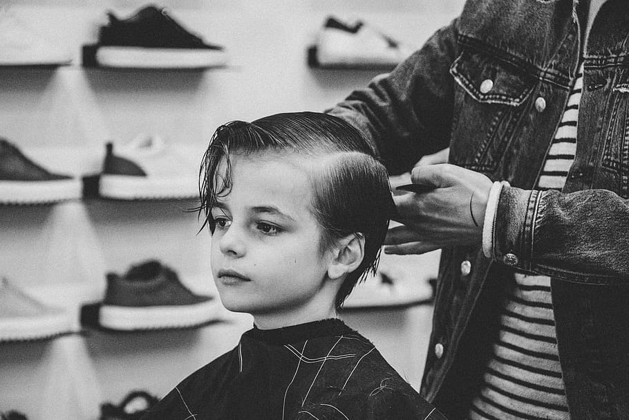 greyscale photo of boy having a haircut, grayscale photo of boy being hair trimmied
