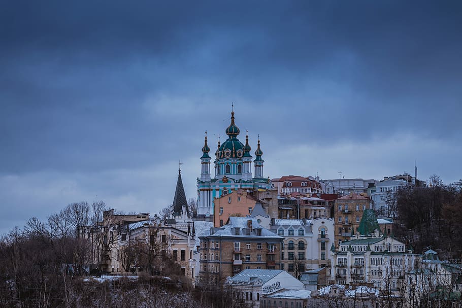 white and blue Gothic structure, assorted-color buildings under cloudy sky at daytime HD wallpaper