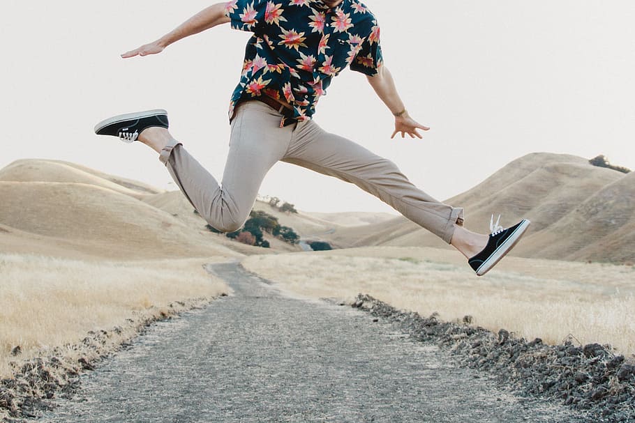 man in black shirt and gray pants jumping, jump shot of person wearing blue, red, yellow button-up short-sleeved shirt and gray pants during day time HD wallpaper