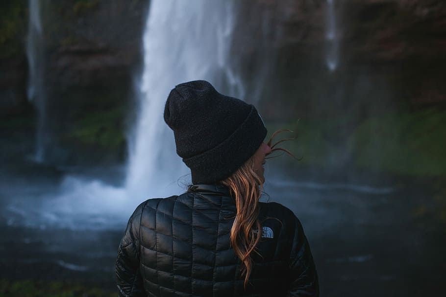 photo of woman wearing black jacket near waterfall, woman standing near waterfalls, HD wallpaper